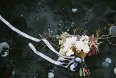 婚礼花束蓝色的丝带谎言黑色的沙子前视图