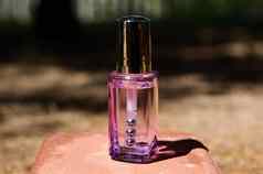 透明的玻璃紫色的瓶化妆品产品皮肤护理眼睛粉红色的石头自然背景