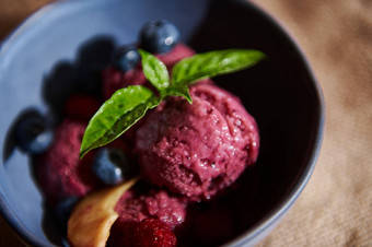 让人耳目一新生素食主义者紫色的浆果冰沙海军陶瓷碗柠檬罗勒叶子蓝莓多汁的桃子