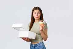 交付生活方式食物概念兴奋快乐女人惊讶收到最喜欢的纸杯蛋糕当地的小糕点商店吃糖果使在线订单白色背景