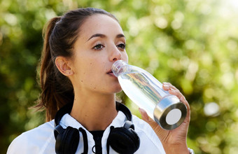 采取很多液体运行有吸引力的运动年轻的女人喝<strong>水站</strong>在户外