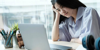 亚洲女孩坐着强调研究在线导师移动PC坐着卧室首页晚上概念在线学习首页