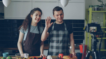 快乐的有吸引力的夫妇记录视频食物视频博客健康的烹饪数字相机厨房首页视频博客社会媒体概念