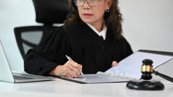 成熟的<strong>女法官</strong>律师律师穿着袍礼服统一的坐着表格槌子锤锤工作法律文档