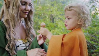 仙女精灵动漫真人秀女人对待婴儿男孩霍比特人糖果绿色森林万圣节概念童话字符孩子们