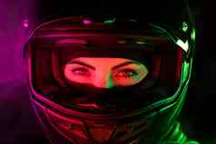 肖像自信骑摩托车的人女人关闭摩托车头盔年轻的司机骑摩托车的人相机粉红色的绿色霓虹灯色彩斑斓的光晚上