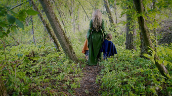 蹒跚学步的男孩动漫真人秀地精霍比特人精灵女人走绿色森林认不出来仙女演讲字符万圣节孩子们概念令人惊异的光
