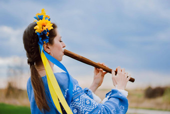 女人玩木管乐器木长笛乌克兰索皮尔卡在户外人音乐文化概念音乐的仪器夫人传统的绣花衬衫蓝色的维希万卡