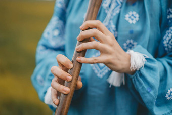 女人玩木管<strong>乐器</strong>木长笛乌克兰索皮尔卡在户外人<strong>音乐</strong>文化概念<strong>音乐</strong>的仪器夫人<strong>传统</strong>的绣花衬衫蓝色的维希万卡