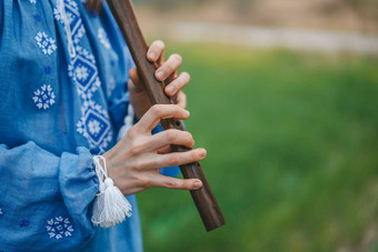 女人玩<strong>木管</strong>乐器<strong>木</strong>长笛乌克兰索皮尔卡在户外人音乐文化概念音乐的仪器夫人传统的绣花衬衫蓝色的维希万卡