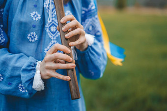 女人玩<strong>木</strong>管乐器<strong>木</strong>长<strong>笛</strong>乌克兰索皮尔卡在户外人音乐文化概念音乐的仪器夫人传统的绣花衬衫蓝色的维希万卡
