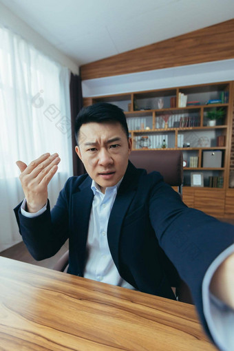 愤怒的亚洲商人老板会说话的视频调用电话工作经典办公室