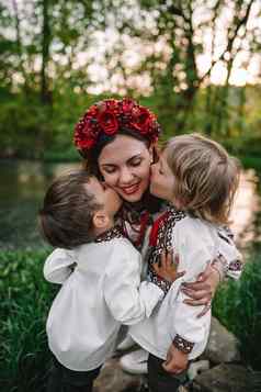 乌克兰男孩接吻妈妈。脸颊快乐家庭传统的刺绣维希万卡衬衫乌克兰兄弟儿子自由国家服装