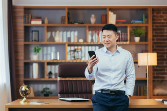 成功的亚洲商人现代首页办公室电话屏幕微笑