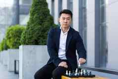 亚洲男人。玩国际象棋商人思考玩国际象棋
