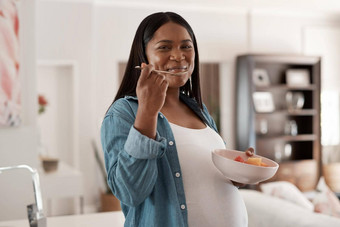 妈妈婴儿吃健康的肖像怀孕了女人吃碗水果首页