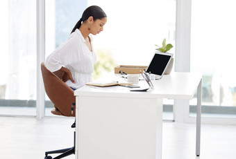 保持富有成效的年轻的女商人坐着桌子上累了现代办公室
