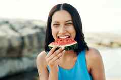 新鲜的多汁的西瓜水果年轻的女人吃片西瓜海滩