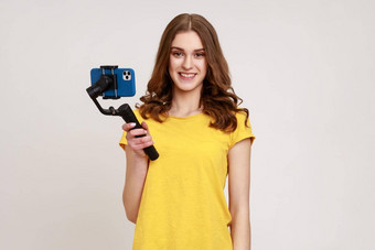 肖像博主少年女孩黄色的t恤芽视频视频博客电子稳定剂持有替身微笑相机