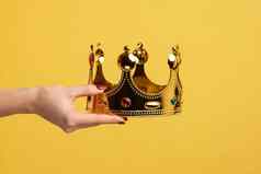 女人手持有金皇冠概念奖仪式享有特权的状态优越的位置