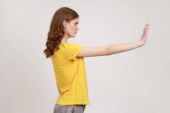 被禁止的一边视图心烦意乱有吸引力的年轻的女人黄色的休闲t恤显示停止手势禁止警告表达式