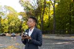 年轻的美丽的女旅游摄影师使照片公园模拟电影相机