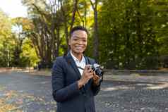 惊讶快乐非洲美国女人相机微笑持有电影相机