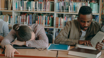 勤奋的学生<strong>准备考试</strong>家庭作业累了的家伙睡觉表格大学图书馆