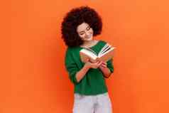 快乐微笑女人非洲式发型发型穿绿色休闲风格毛衣阅读书有趣的情节研究快乐