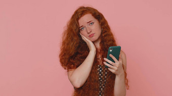 不开心红色头发的人女人智能手机惊讶彩票结果坏《财富》杂志损失不幸的新闻