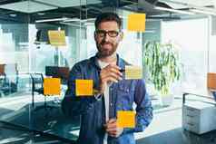 集中思考商人写作色彩斑斓的笔记附加玻璃墙企业家创建视觉待办事项列表业务目标未来职业生涯每天目标概念完成任务