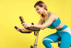 运动女人骑锻炼自行车教程视频聪明的电话有氧运动锻炼