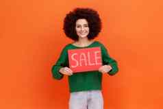 微笑女人非洲式发型发型穿绿色休闲风格毛衣站持有卡出售登记展示巨大的折扣