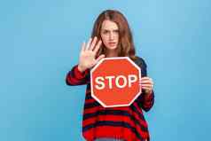 女人愤怒地显示禁止手势持有停止标志警告禁止被禁止的访问