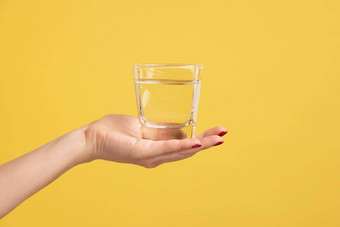 女人手持有玻璃水棕榈广告新鲜的纯饮料恢复水平衡
