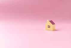 简单的最小的设计微型玩具房子孤立的粉红色的背景抵押贷款财产保险梦想首页概念复制空间