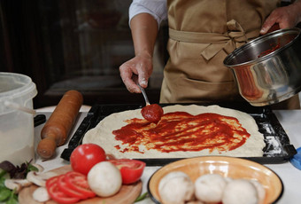 裁剪意大利家庭主妇米色酋长围裙传播新鲜使番茄酱汁滚面团披萨锅