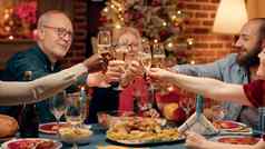 节日多样化的家庭成员享受圣诞节晚餐首页喝香槟