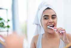 投资牙刷年龄前美丽的年轻的女人刷牙牙齿早....