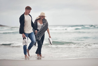 爱的地方带来了更紧密的夫妇持有手漫步海滩