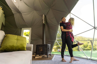 夫妇地理圆顶帐篷舒适的野营豪华露营假期假期生活方式概念在户外小屋风景优美的背景