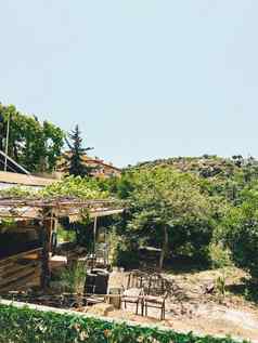 被遗弃的地中海农场房子包围树太阳基斯破旧的农舍成形木家具椅子花园
