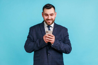 肖像快乐的商人穿官方风格西装手机微笑阅读好新闻消息享受移动应用程序