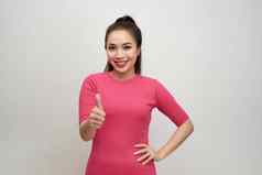 年轻的美丽的女人穿粉红色的衣服快乐拇指手势手批准表达式相机显示成功