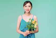 有吸引力的亚洲女人蓝色的衣服持有花束花蓝色的背景