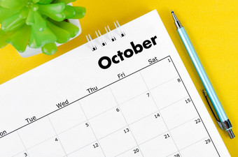 10月桌子上日历笔植物能黄色的背景