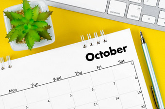 10月桌子上日历笔键盘电脑黄色的背景