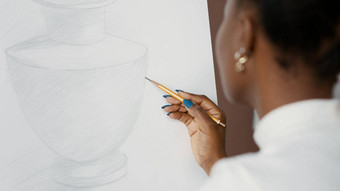 年轻的学生画花瓶设计白色帆布画架