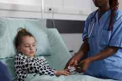 生病了孩子坐着医院儿科病房医疗工作人员监控健康条件血氧计