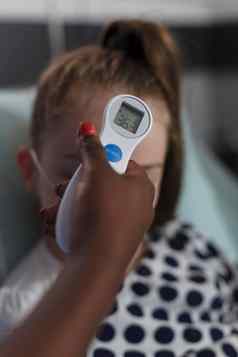 关闭拍摄非洲美国护士测量生病的女孩身体温度
